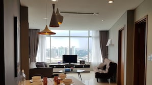 Una sala de estar moderna con comedor, ventanas amplias y vista a la ciudad.