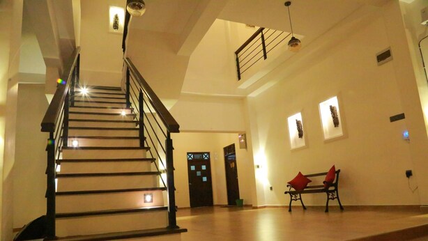 A spacious interior with a staircase, a bench, and a door with a window. - Midigama Holiday Inn (Ahangama)