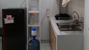 A compact kitchen with a refrigerator, a water dispenser, and a sink. - RJB at Ayodhya Tangerang (Tangerang)