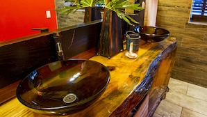 A modern bathroom with a large oval sink, a mirror, and a wooden vanity. - Nomads Hotel - Near San Clemente Pier (San Clemente)