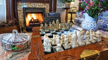 Cozy living room with a classic fireplace, chessboard, and comfortable seating area.