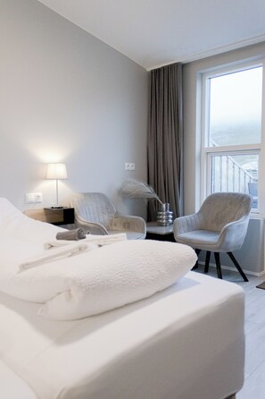 Habitación Deluxe con 1 cama matrimonial o 2 individuales, vista a la montaña | Área de sala de estar | Libros y piso con calefacción 
