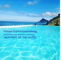 Piscina azul cristalina con una persona nadando, rodeada por una playa y una montaña al fondo.