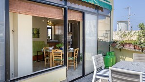 A modern apartment with a sliding glass door leading to a dining area with a table and chairs.