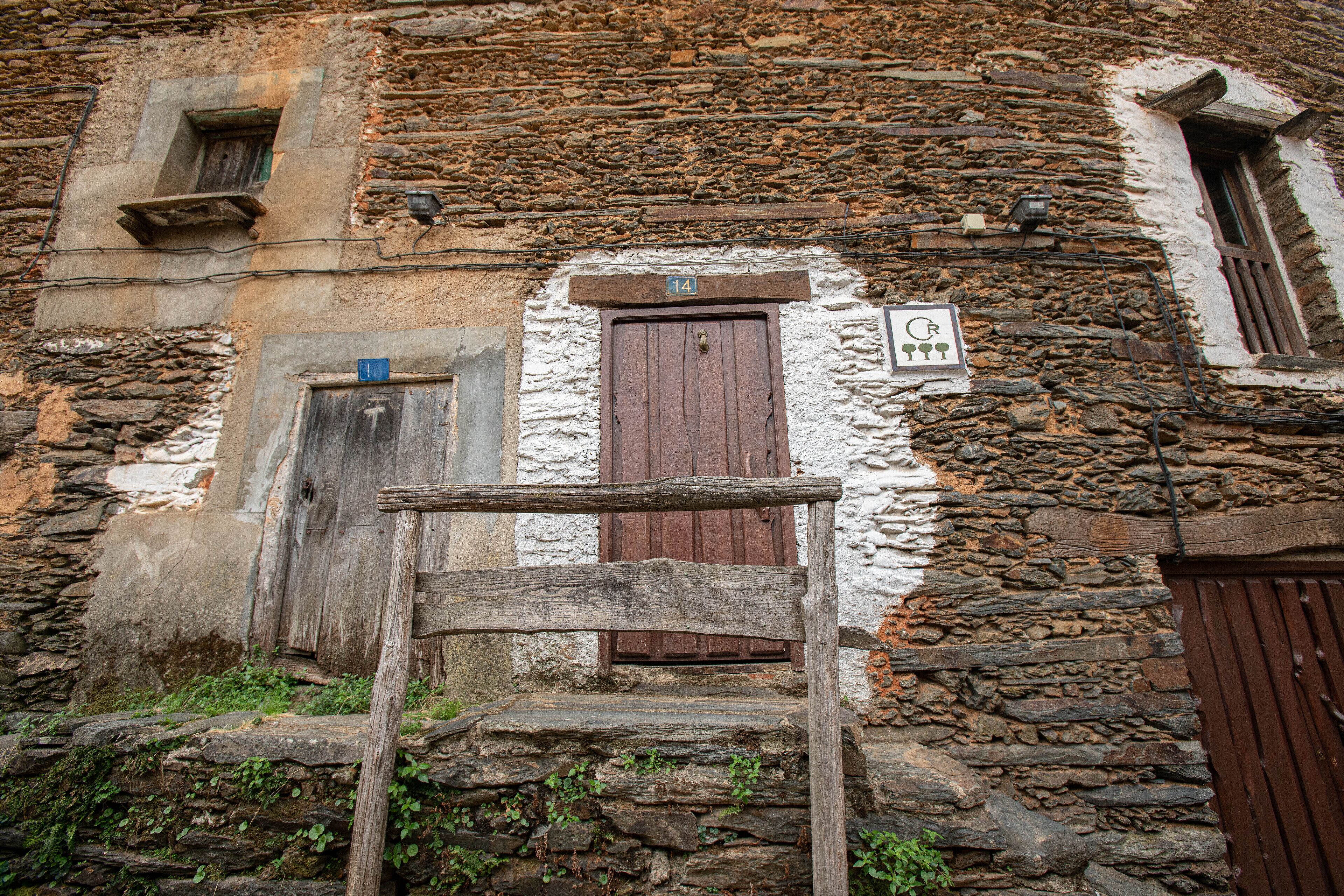 A rustic stone building with a wooden door and a small window.