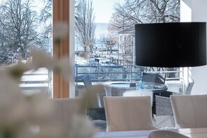 Ein modernes Hotelzimmer mit einem großen Fenster und Blick auf eine Stadtansicht, darunter eine Brücke und Boote.