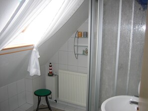 Een douche, handdoeken, zeep, toiletpapier