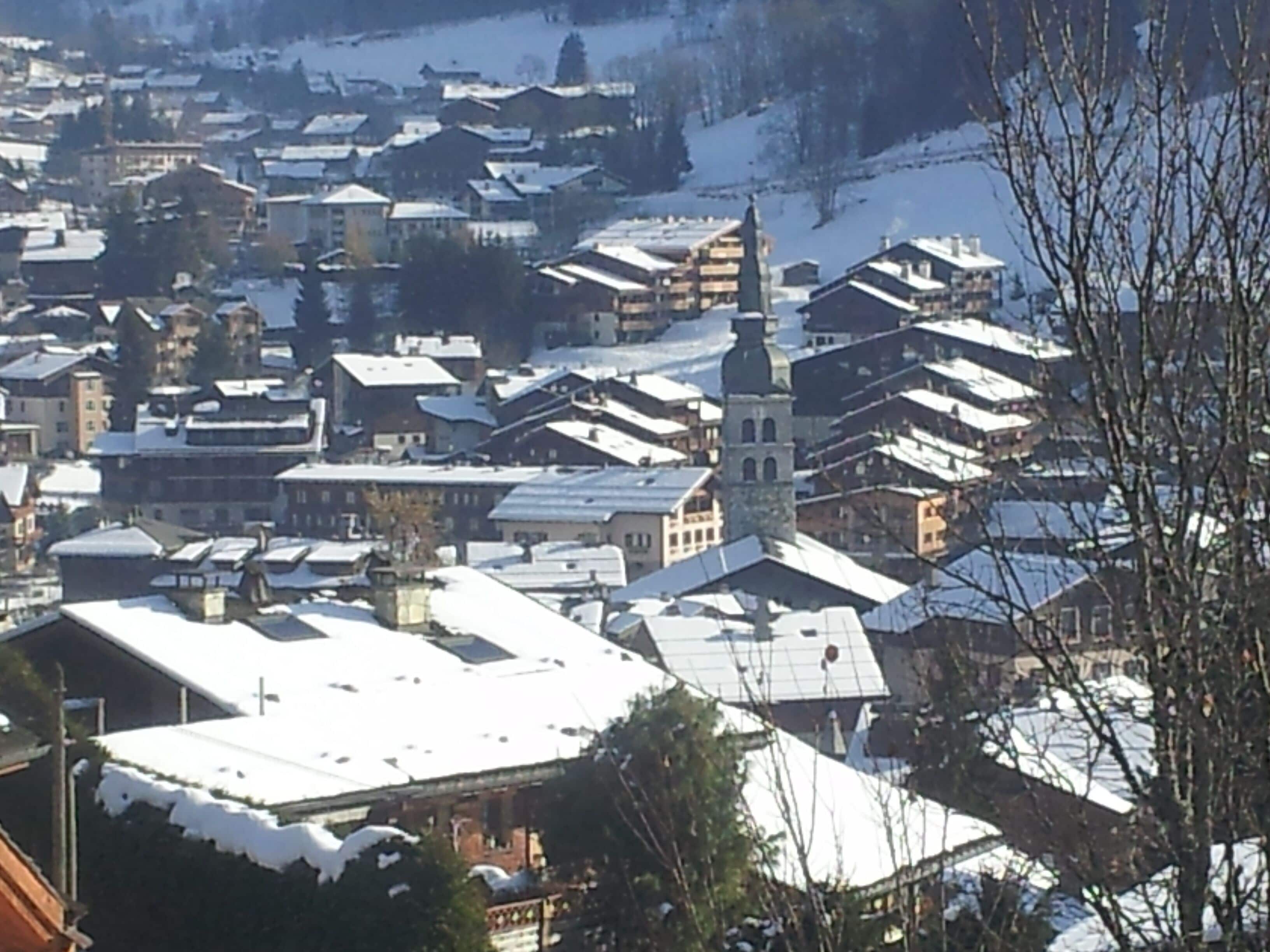 Eine verschneite Stadt mit traditioneller Bebauung und einem markanten Kirchturm.