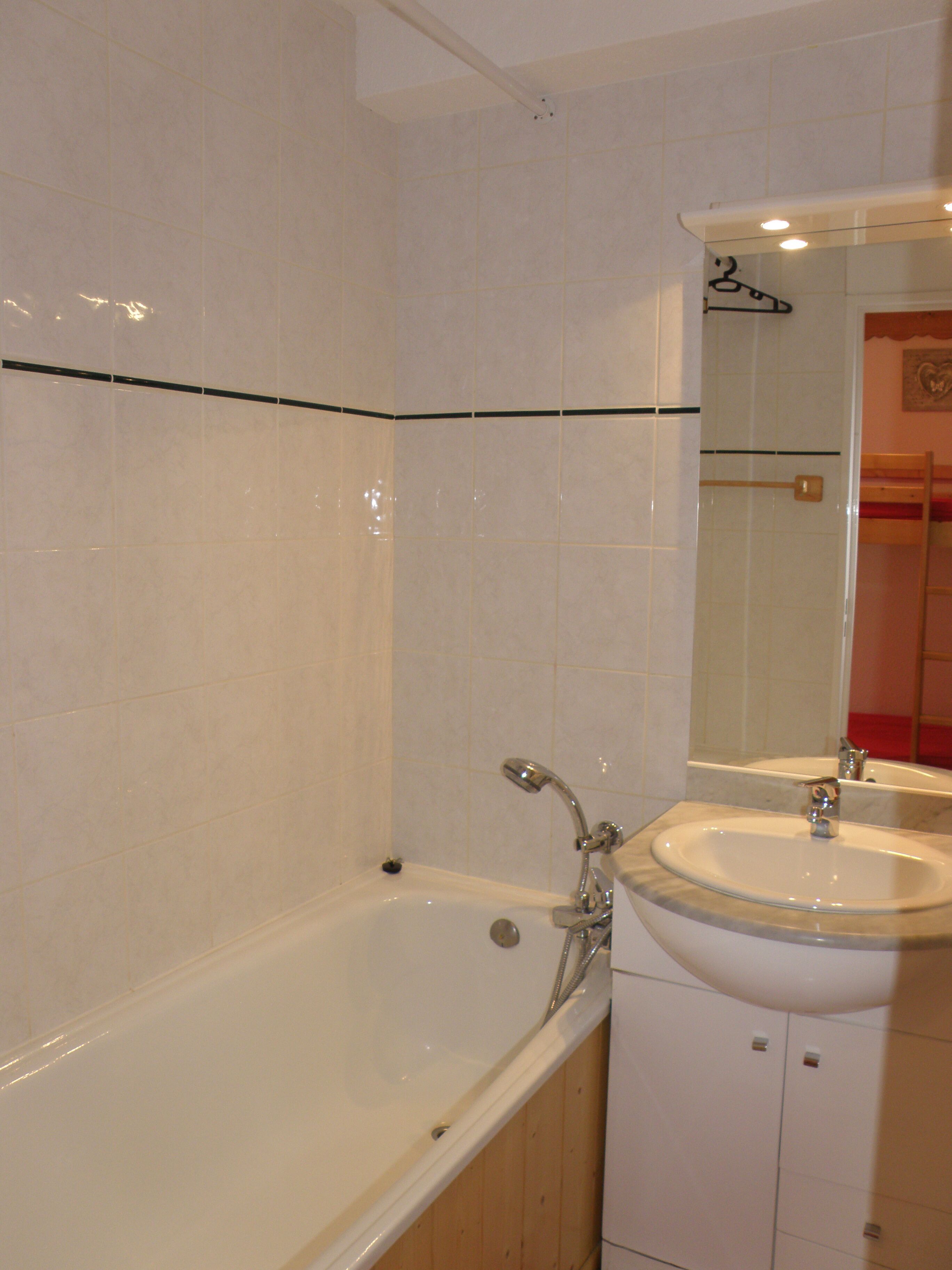 Une salle de bain avec une baignoire, un lavabo et un miroir.