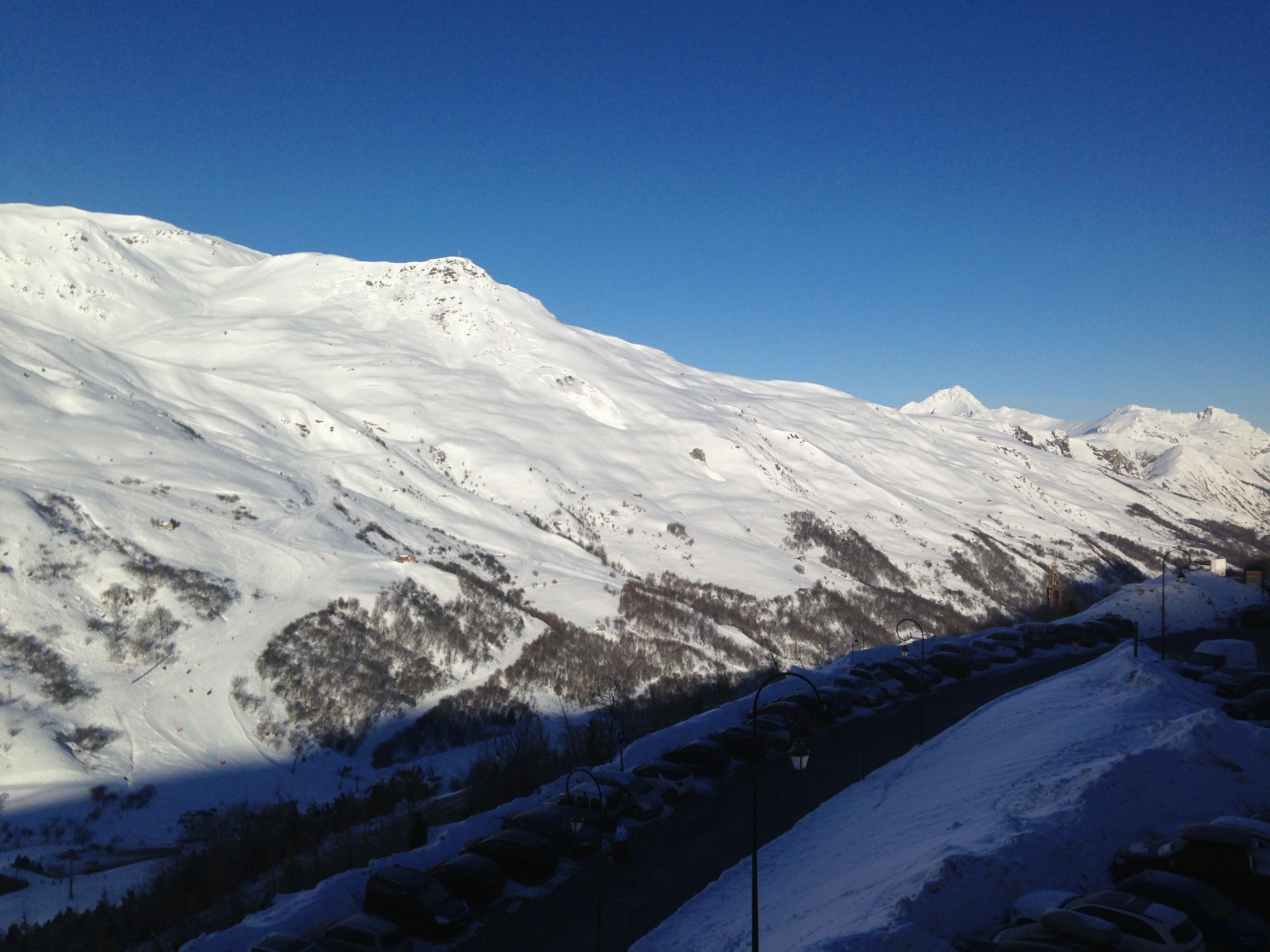 Eine verschneite Berglandschaft mit blauem Himmel.