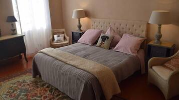 Une chambre à coucher comprenant un lit, deux tables de chevet, une chaise et une lampe de chevet.