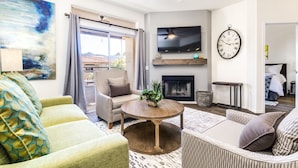 Ein Wohnzimmer mit Kamin, Fernseher und einer Wanduhr.