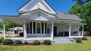 A two-story house with a porch, a chimney, and a number 242 on the front. - Cottage on the Boulevard - Renovated, Historic Downtown Wendell-3 Beds, 2 Baths (Wendell)