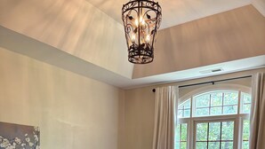 A bedroom with two beds, a chandelier, a window with curtains, and a painting on the wall. - Location!! Pis Nat F., DuPont, Brev. & Ash. 5 bedrooms, 3.5 baths, Sleeps 16! (pisgah forest)
