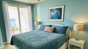 Een slaapkamer met een groot bed, een schilderij aan de muur en uitzicht door het raam.