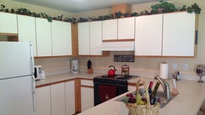 A kitchen with white cabinets, a stove, a microwave, and a coffee maker. - Welcome to the Bean's Pod :-) (Leavenworth)