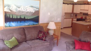A living room with a sofa, a lamp, and a painting of mountains. - Welcome to the Bean's Pod :-) (Leavenworth)