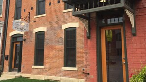 A two-story brick building with a sign for Drake House Vacation Rentals. - Drake House: City View (Private Hot Tub) (Dubuque)
