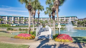 A hotel with a central walkway, palm trees, and a water feature. - Aug/Sept Openings SAVE Large Walk Off  Patio w/Grill. 2 Pools, Beach Service!!!! (Miramar Beach)