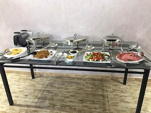 A buffet table with various dishes and serving utensils.