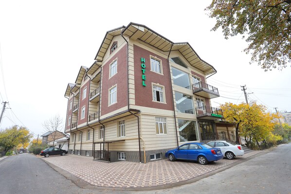 A multi-story hotel with a brick facade, large windows, and a balcony on the upper floor.