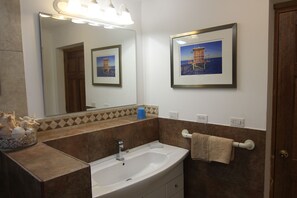 A bathroom with a sink, mirror, and towel rack.