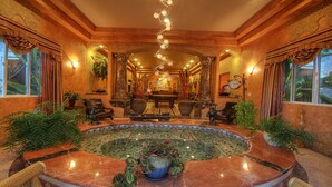 A luxurious lobby with a marble fountain, comfortable seating, and a grand chandelier. - Paradise Vacation Estate - Largest Luxury Private Vacation Resort (Temecula)