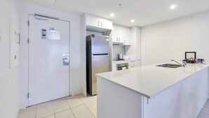 A modern kitchen with white cabinetry, a stainless steel refrigerator, and a white countertop. - Darwin City Harbour Views-above the Oak Restaurant (Darwin City)
