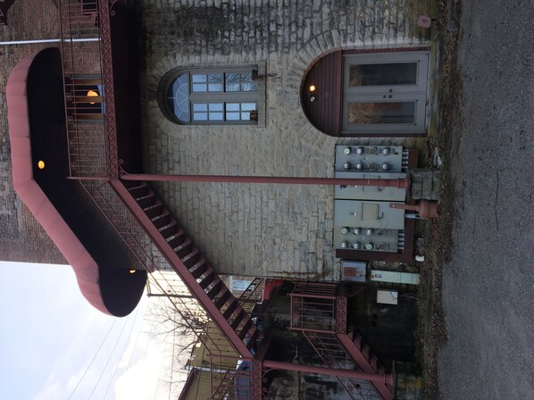 A building with a staircase, a small window, and a door.