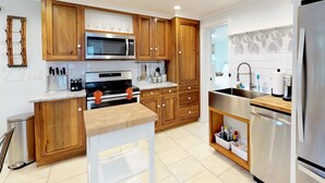 A modern kitchen with wooden cabinets, stainless steel appliances, and a built-in oven.