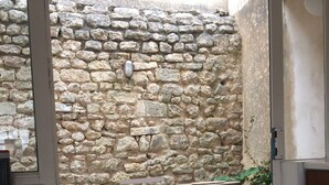 A stone wall, a metal folding chair, and a concrete floor.