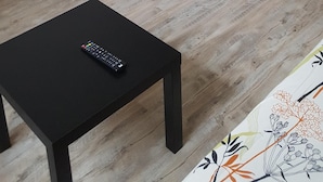 A compact kitchenette with a small refrigerator, a sink, and cabinets. There's a black table with a remote control on it. - STUDIO 17m², 5 BEDS (Les Orres)