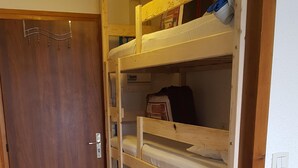 A bunk bed room with a wooden door, a white wall, and a wooden floor. - STUDIO 17m², 5 BEDS (Les Orres)