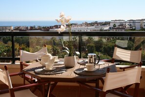 Una mesa de comedor con sillas y vistas al mar y edificios.