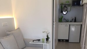 A compact living space with a kitchenette, a dining area with a small table and chairs, and a sofa. - W-Lan, kitchenette, bathroom, shower, sofa bed, smart TV (Leverkusen - Hitdorf)