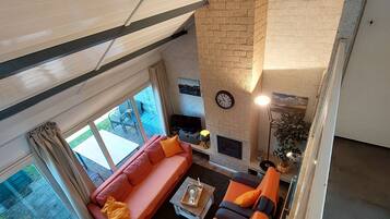 Télévision, cheminée, table de tennis de table, livres