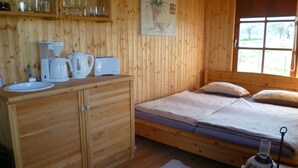 A wooden cabin with a bed, a sink, and a coffee maker. - Harz vacation under the apple tree  (Cattenstedt)