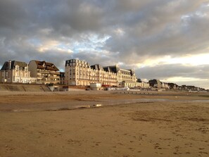 A coastal hotel with multiple floors, balconies, and a beach view. - Studio waterfront Cabourg, garden view (Cabourg)