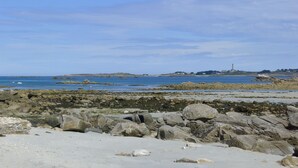 A rocky shoreline with a lighthouse in the distance. - bright, contemporary new villa 2 minutes from beautiful beaches (Santec)