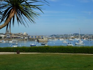 A marina with various boats docked, a palm tree, and a town in the background. - bright, contemporary new villa 2 minutes from beautiful beaches (Santec)