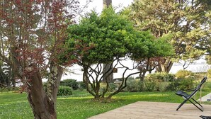A wooden deck with two black and white lounge chairs. - Nestled in a wooded park, with the beach just 3 minutes away (Pénestin)