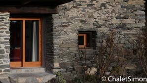 Un bâtiment en pierre avec des portes et des fenêtres en bois.