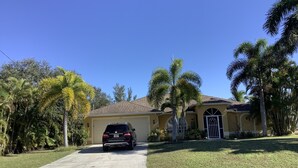 A residential house with a garage, a driveway, and a lawn.