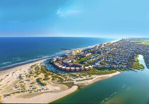An aerial view of a coastal residential area with beachfront properties, a marina, and a city skyline in the distance. - Beautiful Ocean and Inlet Views From This Penthouse Corner Unit (North Myrtle Beach)