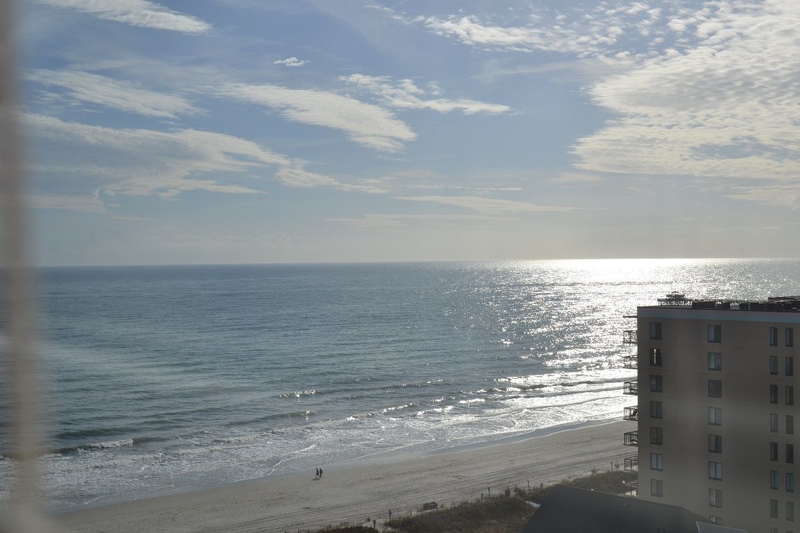 Une vue sur la plage avec un bâtiment au premier plan.