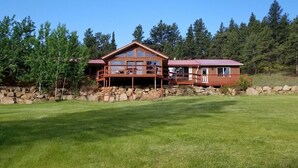 Un chalet à deux étages, avec une façade en bois, un balcon et des fondations en pierre.