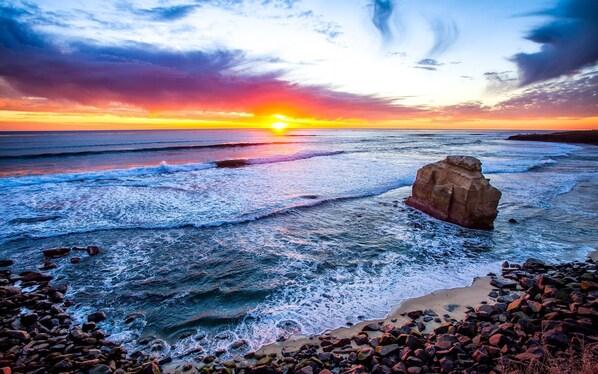 Experience the serene beauty of the coastline with its rugged shoreline and crashing waves.