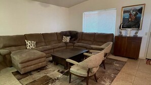 Una sala de estar con un sofá modular, una mesa de centro y una lámpara de pie.