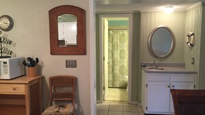 Un espacio habitable compacto con kitchenette, comedor y baño.