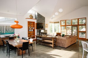 Un espacio habitable amplio con un ventanal grande, una chimenea y un conjunto de asientos cómodo.